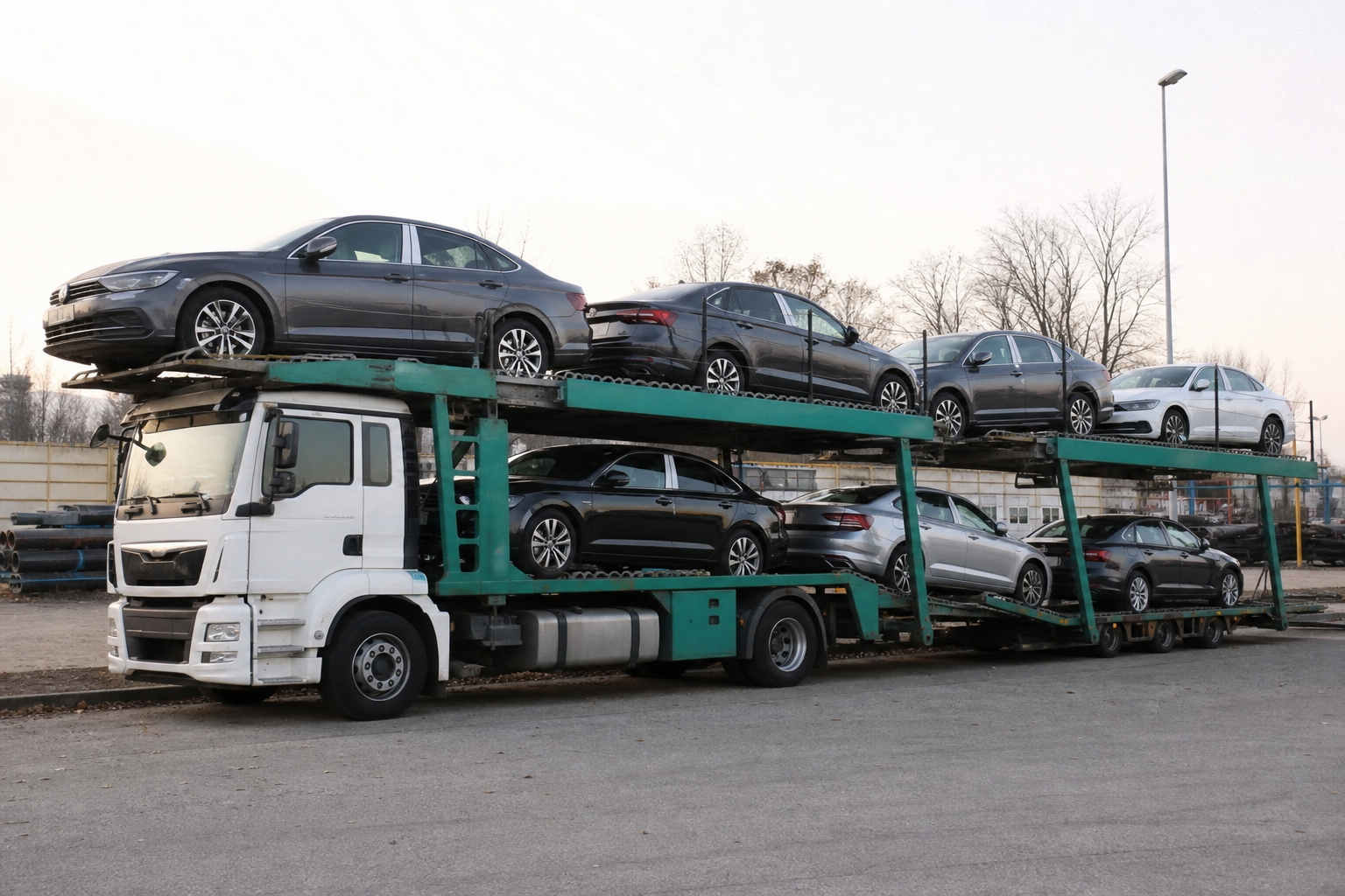 Beladener Autotransporter auf einem Hof — die Alternative zur Überführung auf eigener Achse